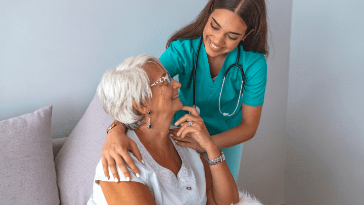 a nurse and an old lady smiling to each other 