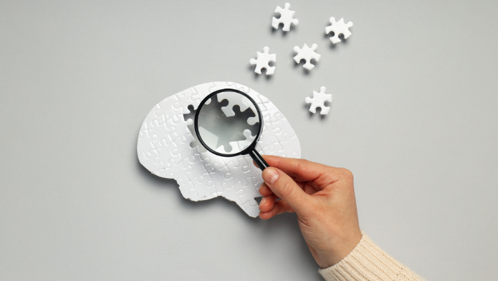 a magnifying glass looking at a puzzle brain