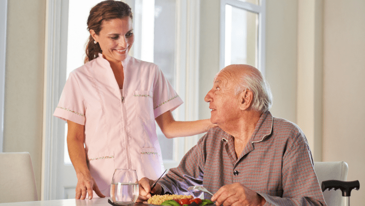 senior with caregiver about to eat