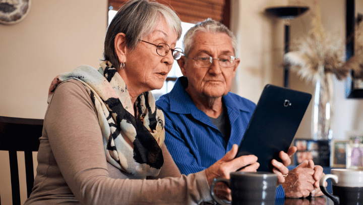 a senior couple searching on their tablet for a senior living community