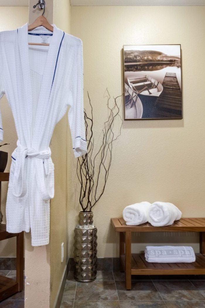 Robe, bench, and picture in our spa room at Heritage Menomonee Falls.