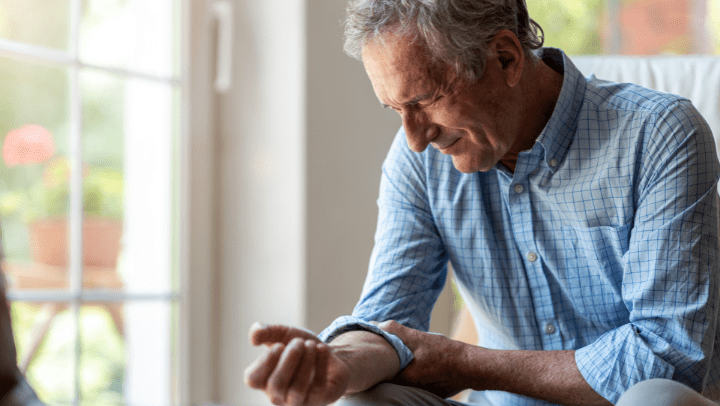 an old guy touching his arm