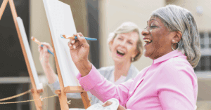 an old lady painting on a canvas
