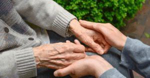 senior holding younger hands