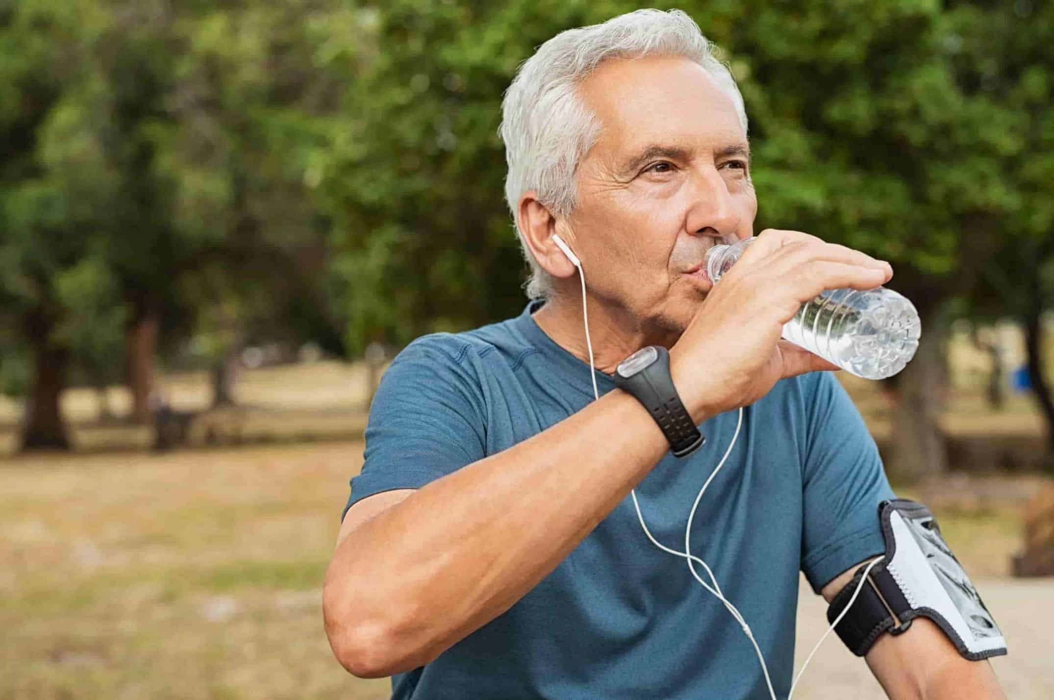 Senior man drinking water for proper hydration.