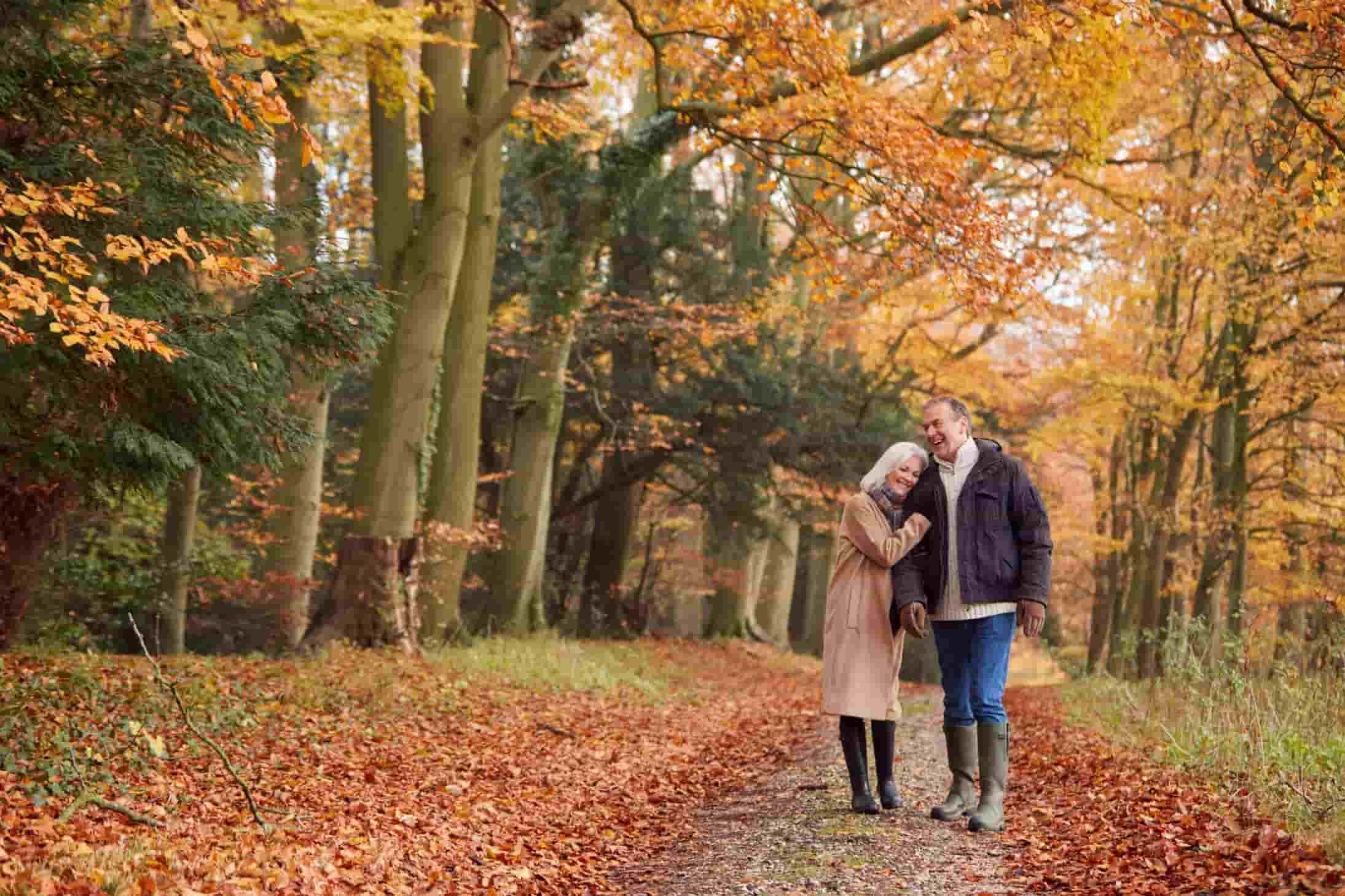 seniors walking through autumn forest