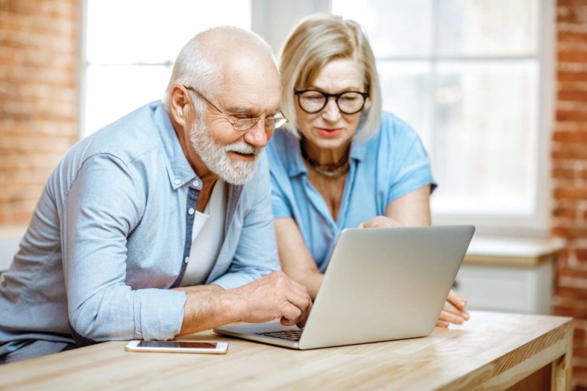 A senior man and his daughter finding a memory care facility online.