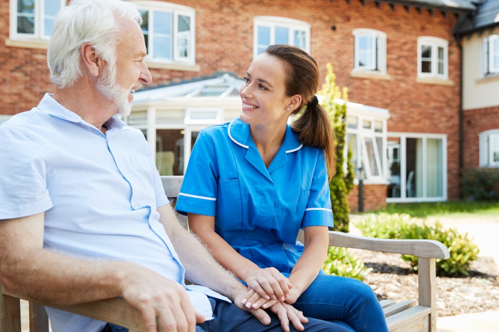 shutterstock_1178447647 Senior man speaking to caregiver outside senior living community