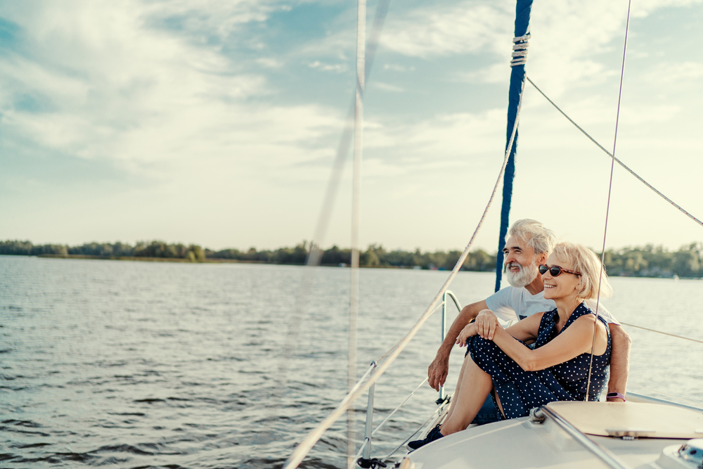 A senior couple on a sail boat out on the lake