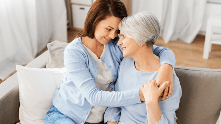 a senior mother and her daughter hugging eachother