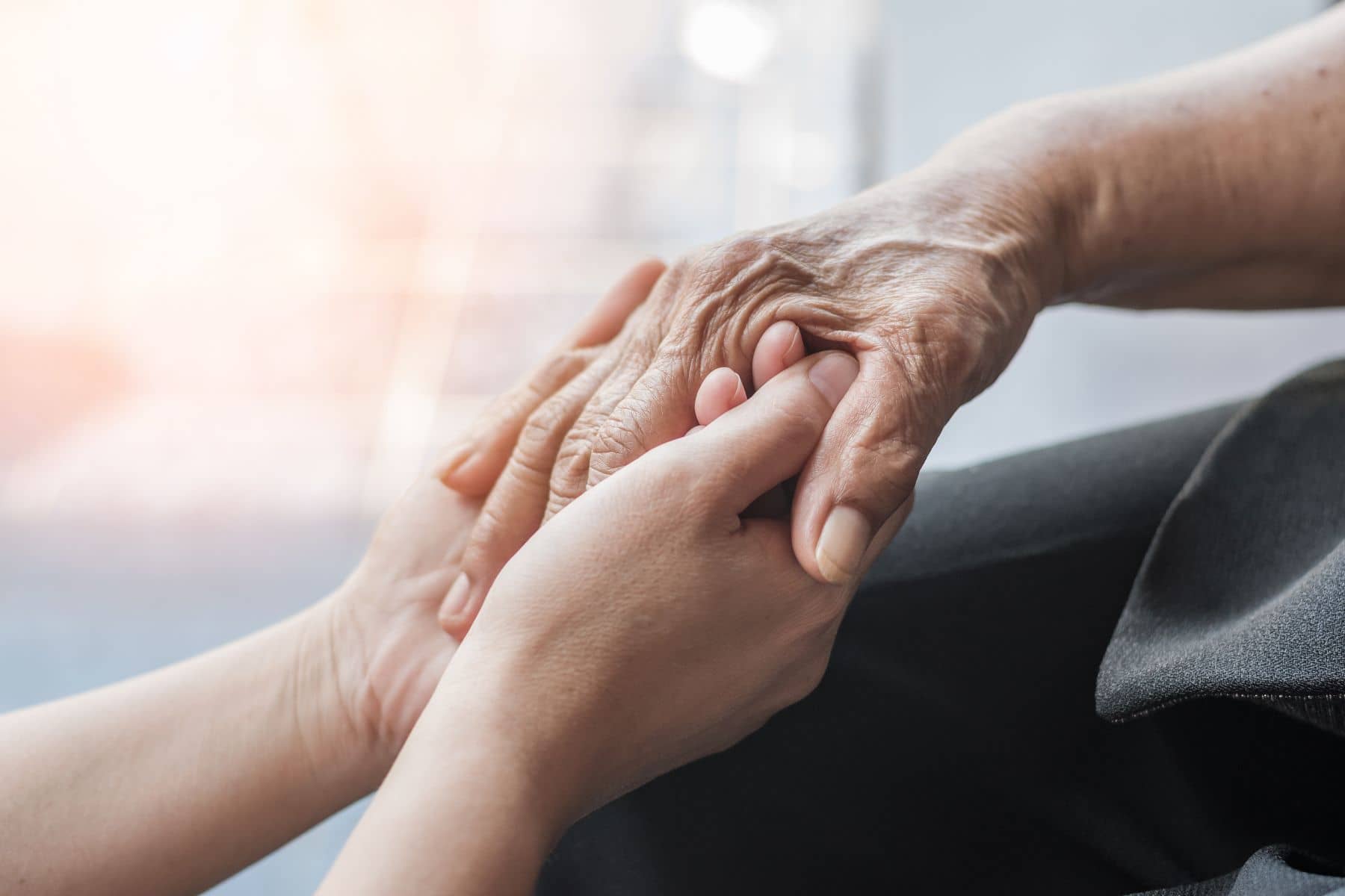 A patient with Alzheimer’s being comforted by a caregiver.