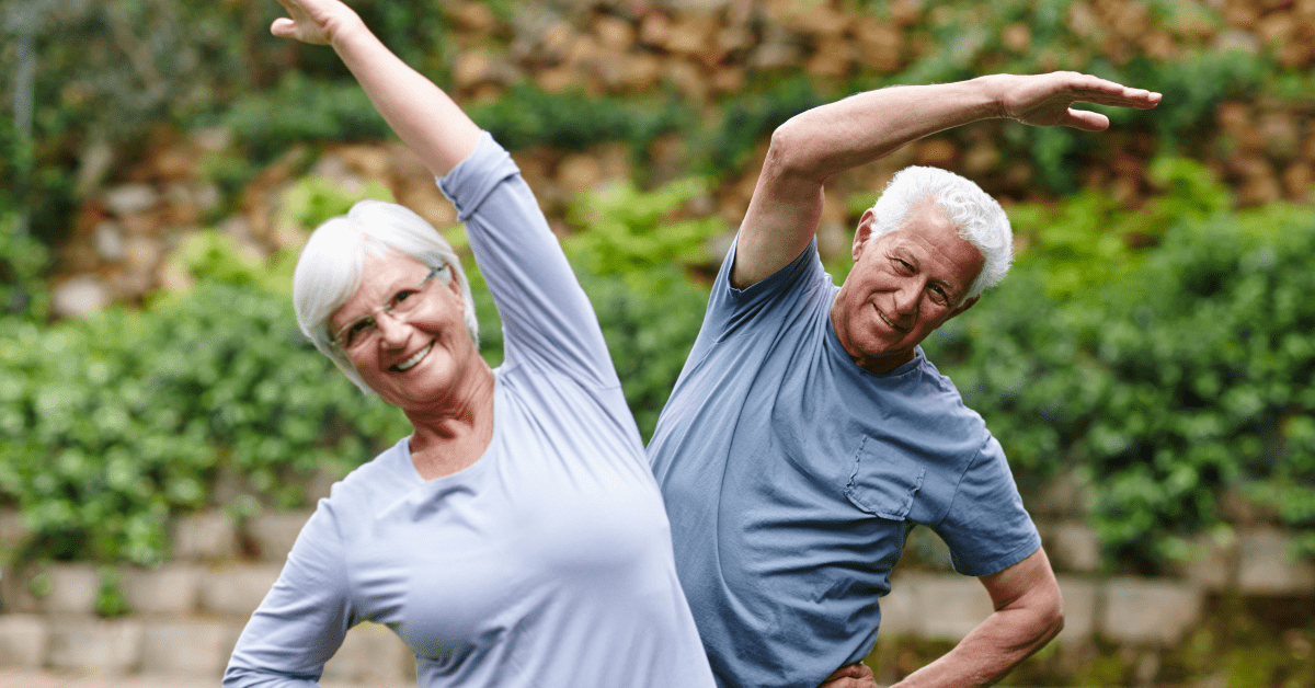 a senior couple stretching outside the assisted living