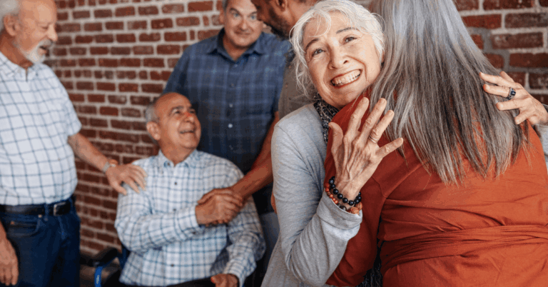 a group of seniors hugging each other at assisted living