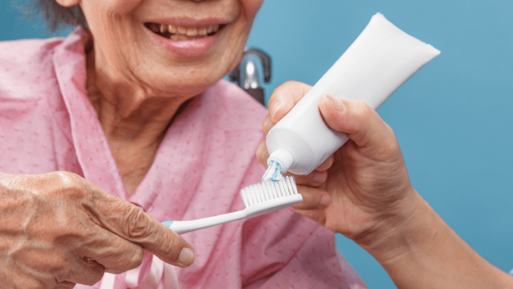 old woman brushing her teeth