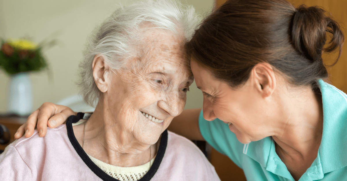 old lady smiling with caregiver