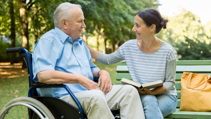 a caregiver reading to an old senior man 