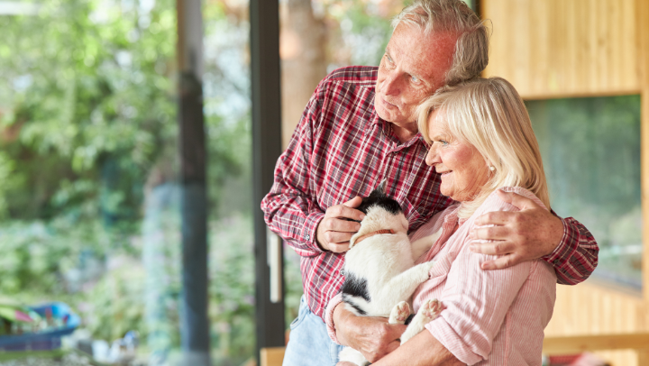 a senior couple hugging their dog