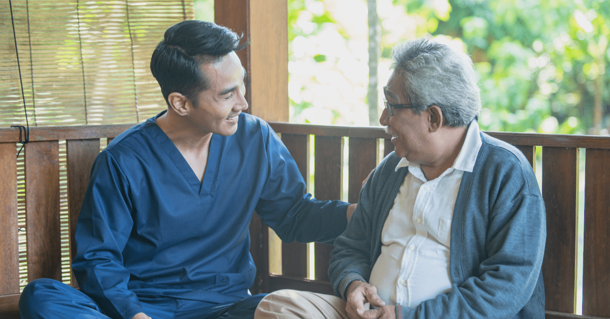 a senior man talking with his caregiver at assisted living
