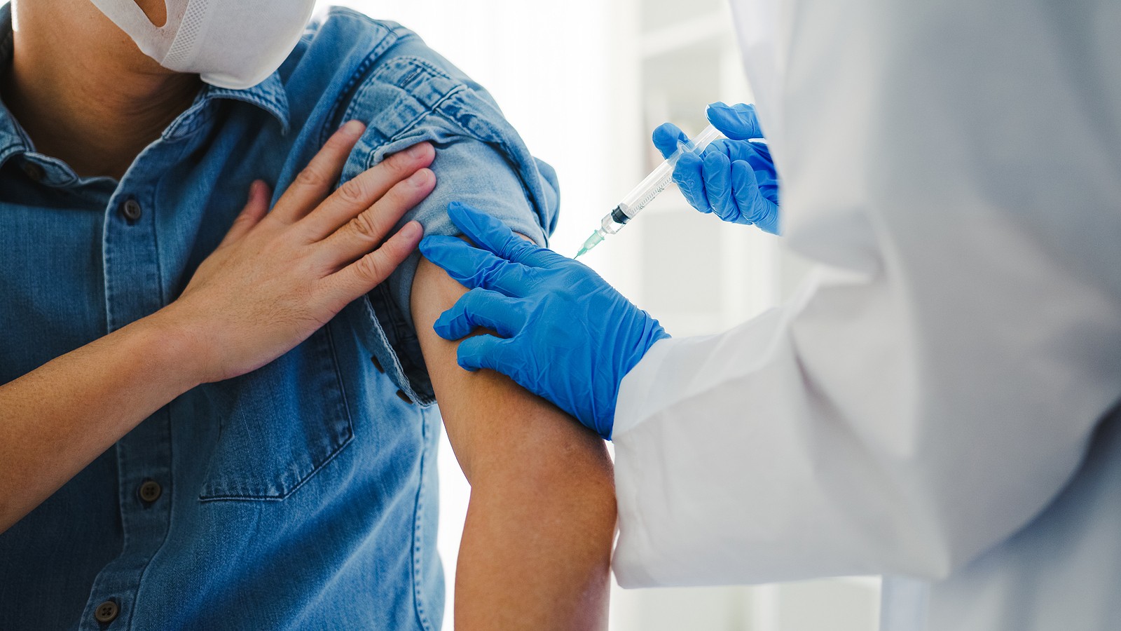 Senior receiving flu vaccine from doctor