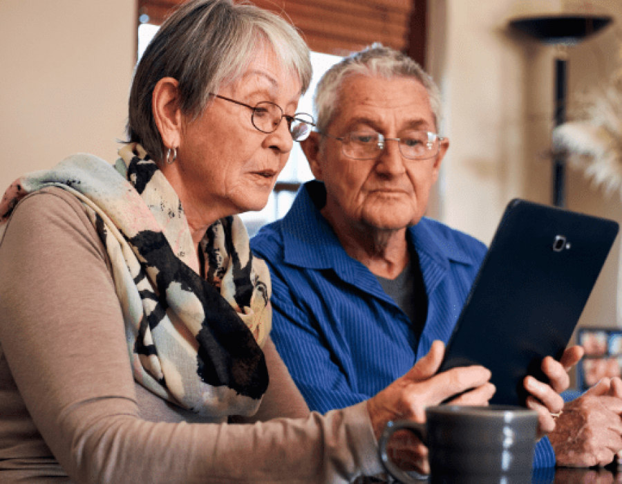 a senior couple searching on their tablet for a senior living community