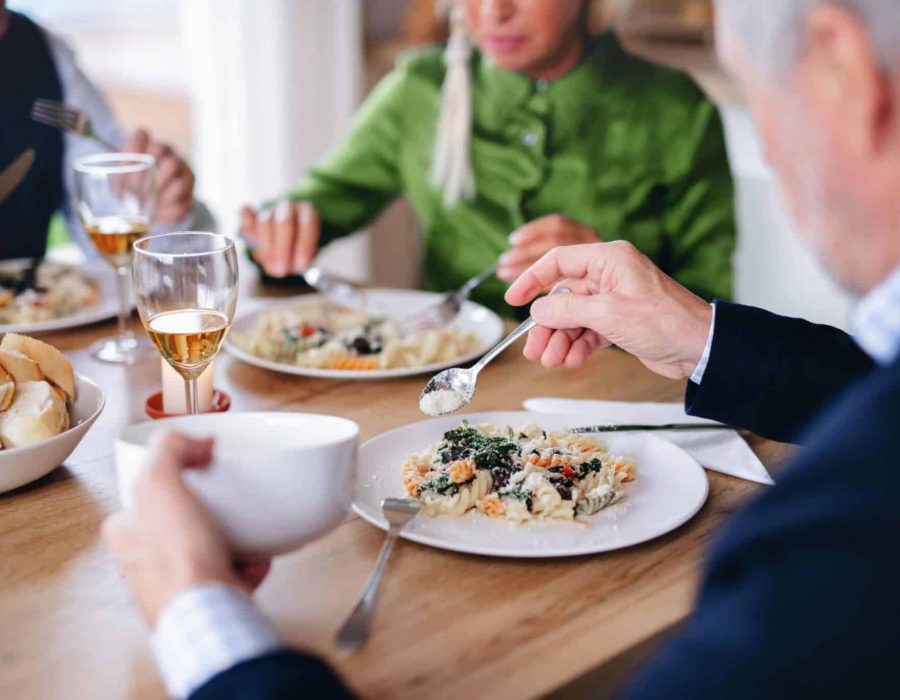 A group of seniors gather together for dinner in senior living dining.