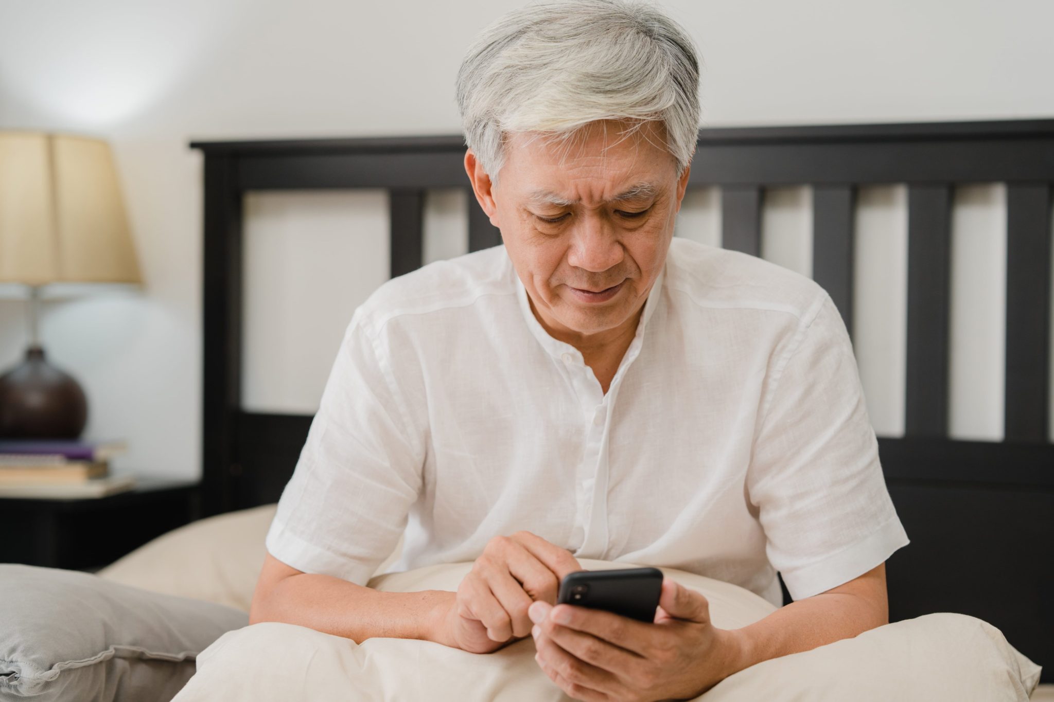 A senior man using a telephone and avoiding senior scams.
